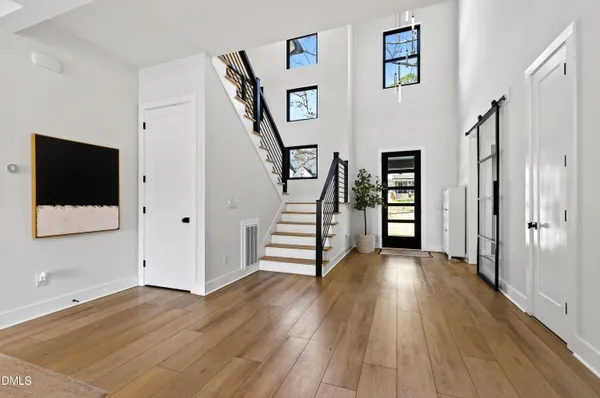 a view of a hallway with wooden floor and stairs