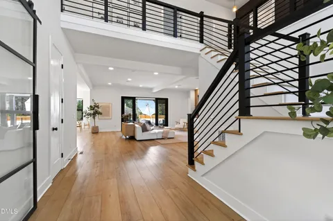 a view of a hallway with wooden floor and stairs
