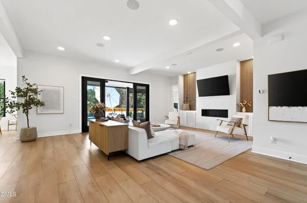a kitchen with stainless steel appliances a stove a sink a refrigerator white cabinets and wooden floor