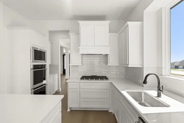 a kitchen with white cabinets and stainless steel appliances