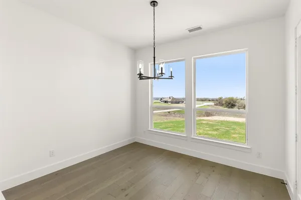 a view of a room with wooden floor and windows