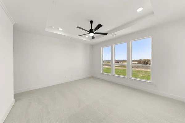an empty room with windows and a ceiling fan