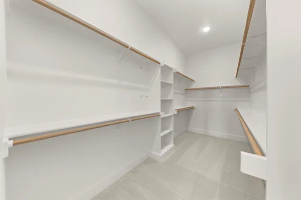 a view of walk in closet with empty racks