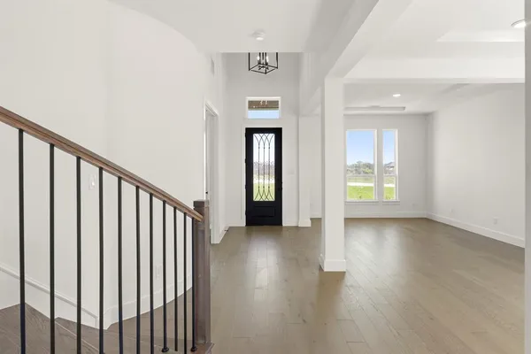 a view of a hallway with wooden floor and stairs