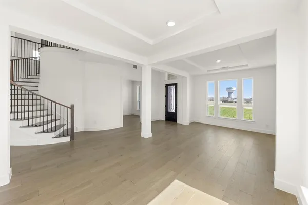a view of a hallway with wooden floor and windows