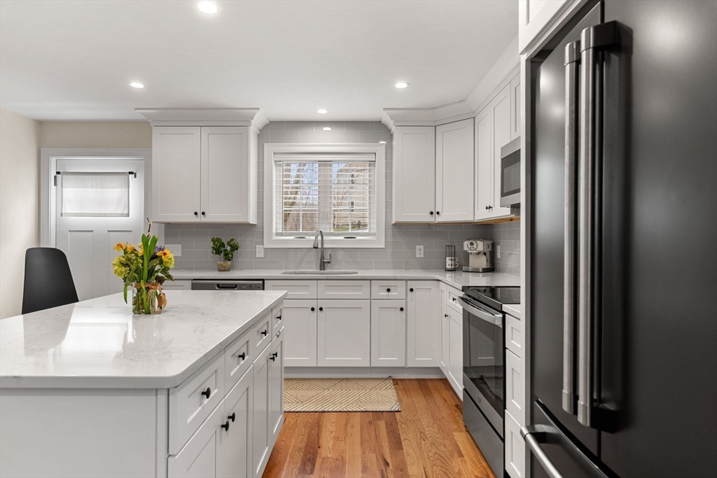22 Pond Street, Unit 2 Amesbury, MA 01913 - Photo 5 of 40 a kitchen with stainless steel appliances granite countertop a refrigerator a stove a sink dishwasher and white cabinets with wooden floor