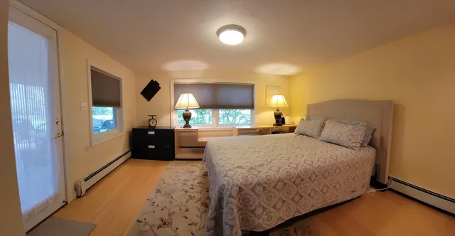 a living room with a bed furniture and a flat screen tv