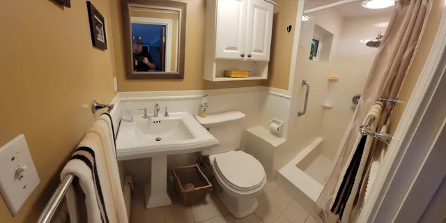 a bathroom with a sink a toilet and a mirror