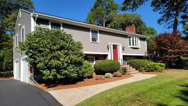 a view of a house with a yard and potted plants