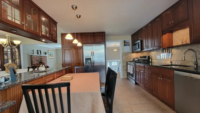 a kitchen with stainless steel appliances kitchen island granite countertop a sink and cabinets