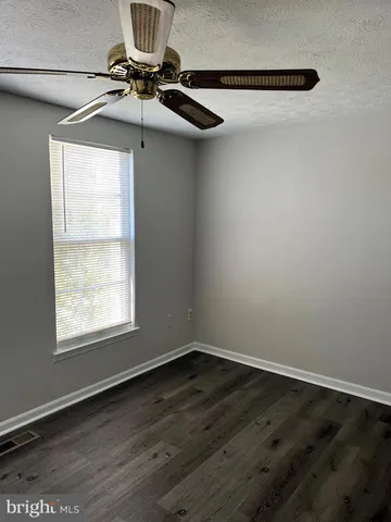 a view of a room with wooden floor and windows