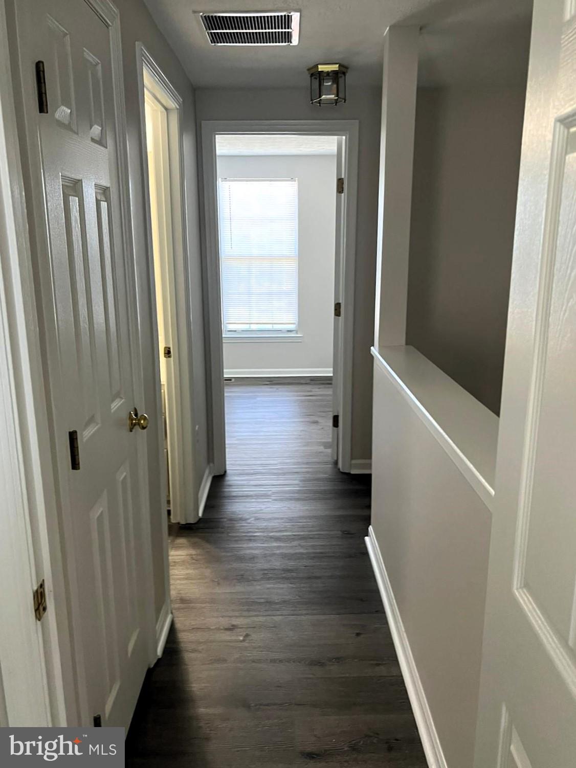 2243 Riding Crop Way Windsor Mill, MD 21244 - Photo 9 of 17 a view of a hallway with wooden floor and staircase