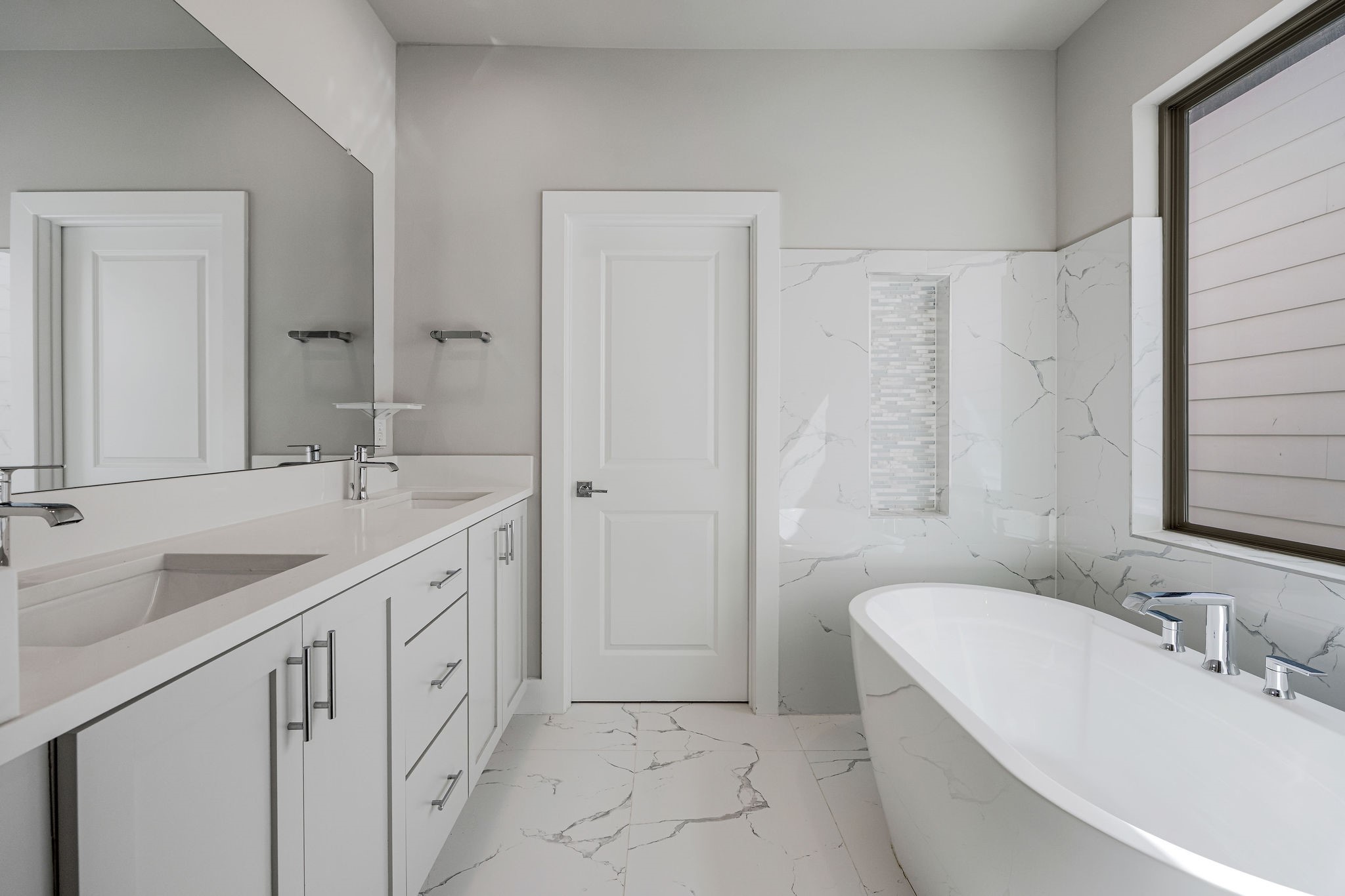 540 Janisch Road, Unit A Houston, TX 77018 - Photo 14 of 18 Spa-inspired primary bath featuring a freestanding soaking tub, dual-sink vanity, large-format tile, and abundant natural light.
