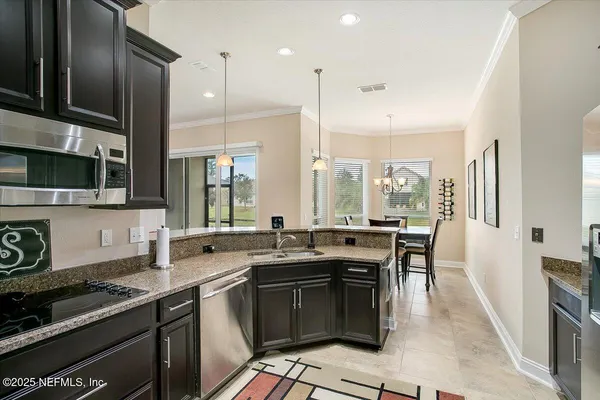 a kitchen with granite countertop a sink stove and cabinets