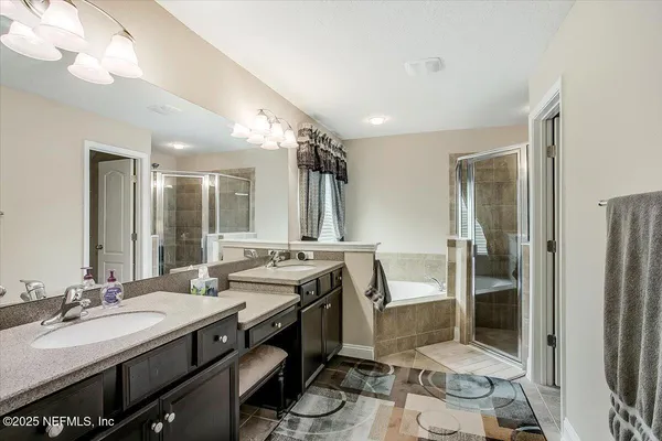 a bathroom with a double vanity sink a mirror and a shower