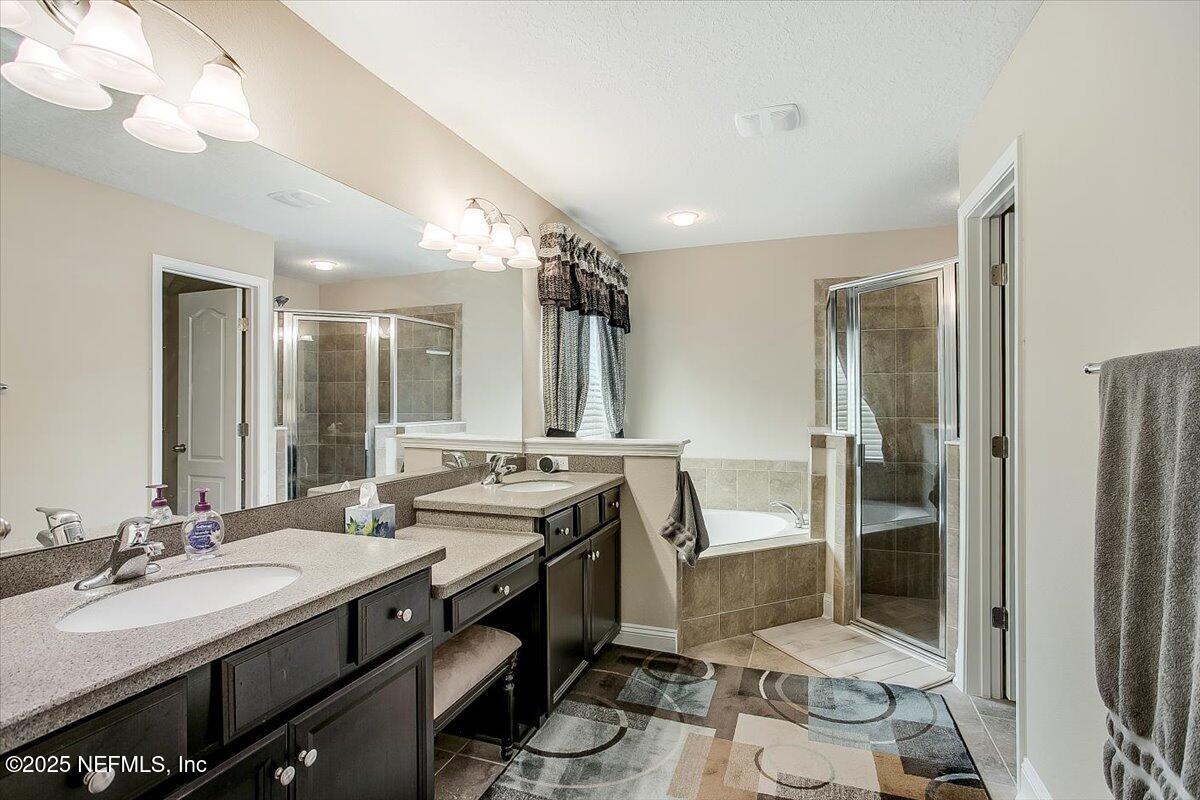 11780 Paddock Gates Drive Jacksonville, FL 32223 - Photo 19 of 39 a bathroom with a double vanity sink a mirror and a shower