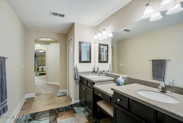 a en suite bathroom with a double vanity sink and a mirror