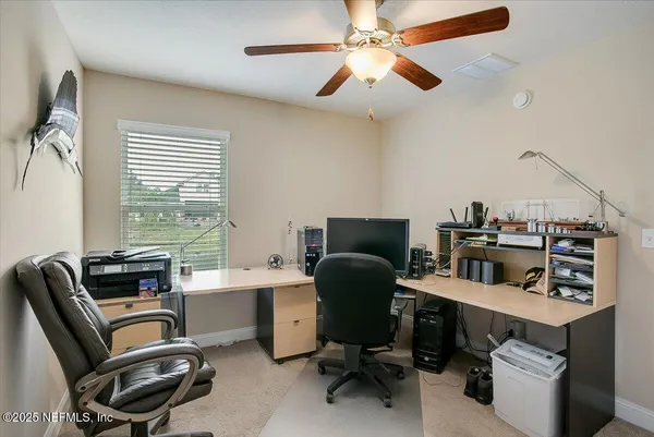 a view of a workspace with furniture and a window