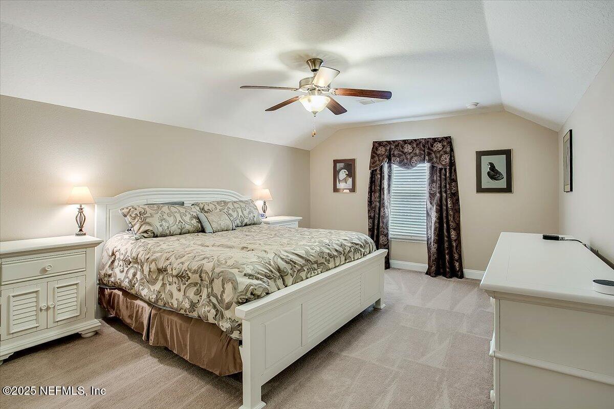 11780 Paddock Gates Drive Jacksonville, FL 32223 - Photo 27 of 39 a spacious bedroom with a bed and a chandelier