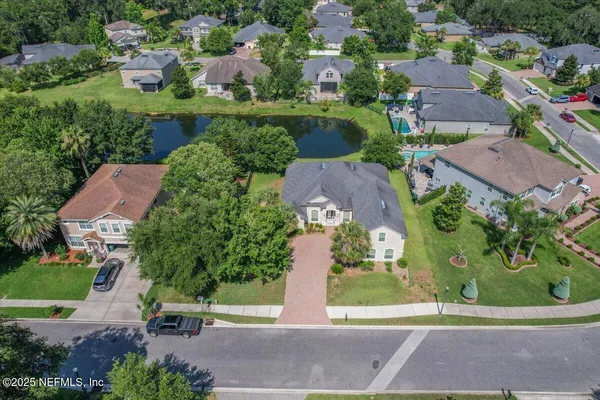 an aerial view of a house with a garden and lake view