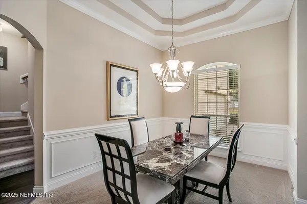 a view of a dining room with furniture wooden floor and chandelier