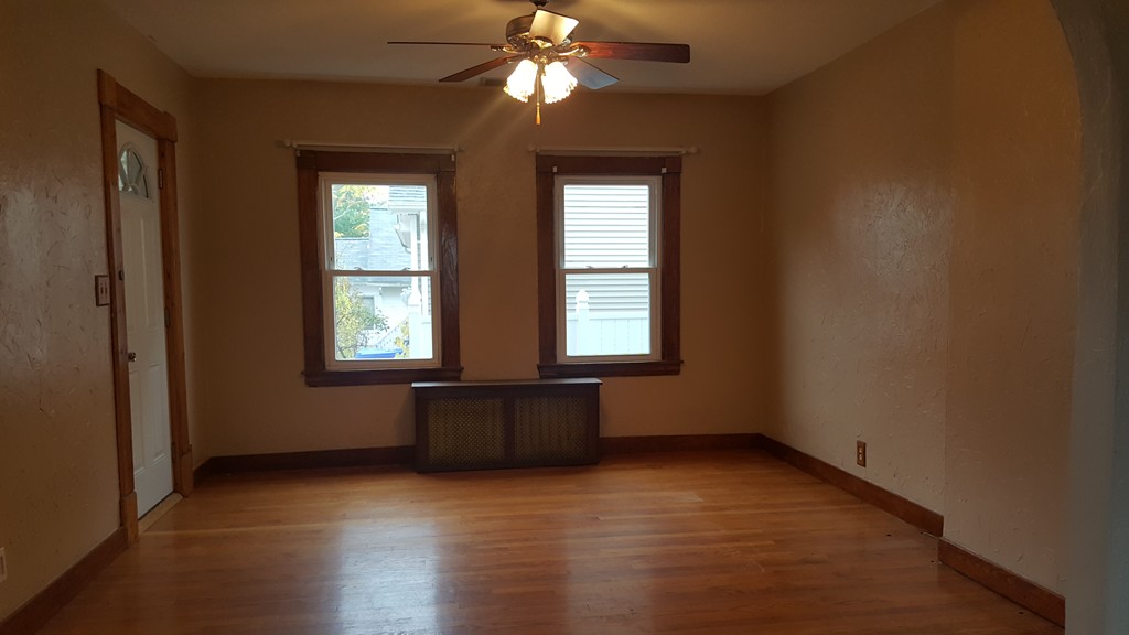 48 Agnes Street Springfield, MA 01118 - Photo 9 of 23 an empty room with wooden floor windows and chandelier fan