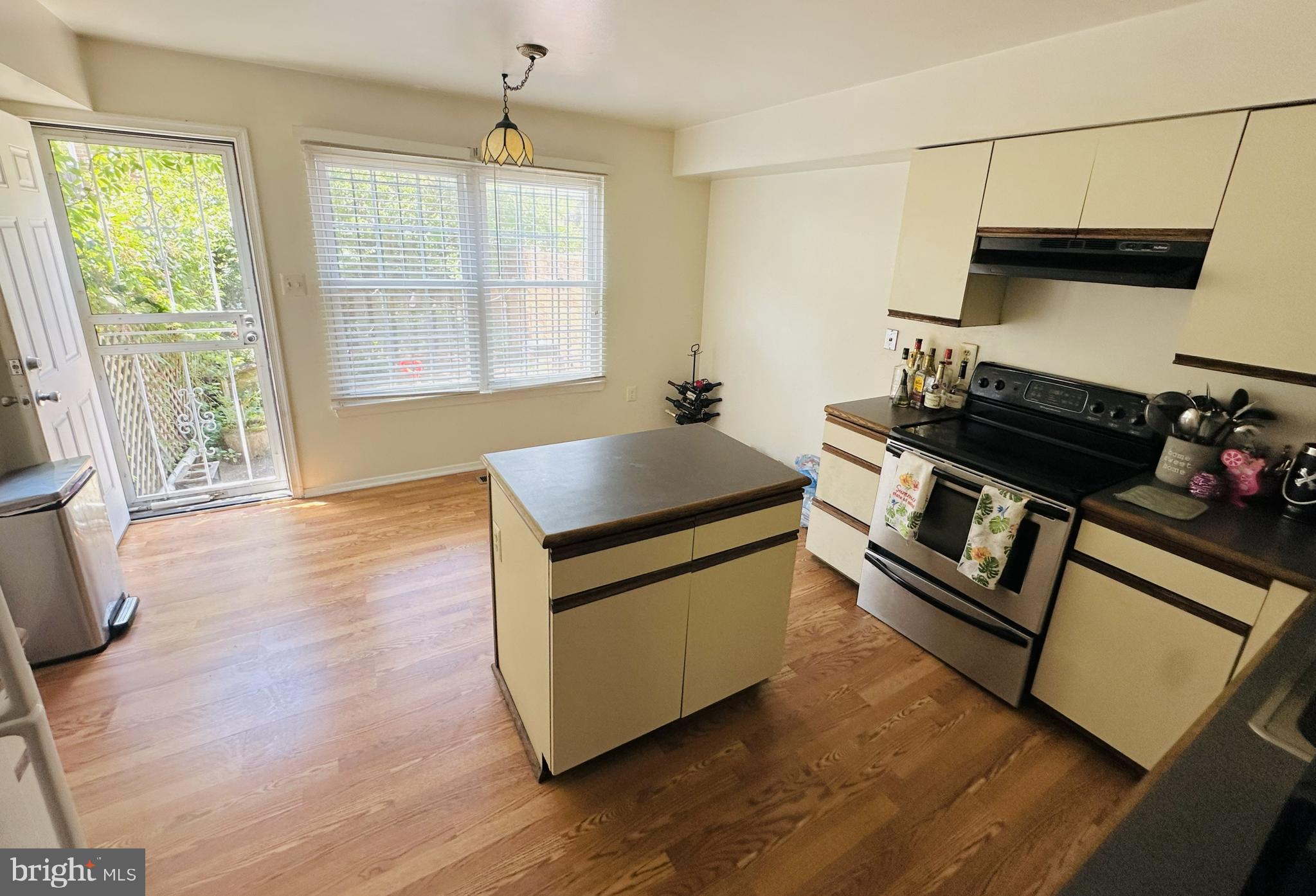 28 North Wolfe Street Baltimore, MD 21231 - Photo 9 of 25 a kitchen with granite countertop a stove a sink a window and wooden floor