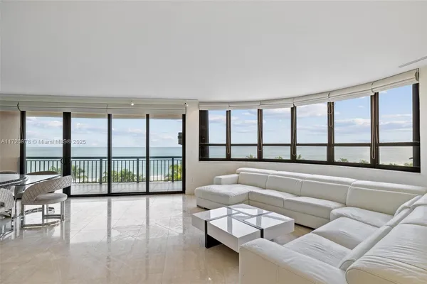 a living room with furniture and floor to ceiling windows