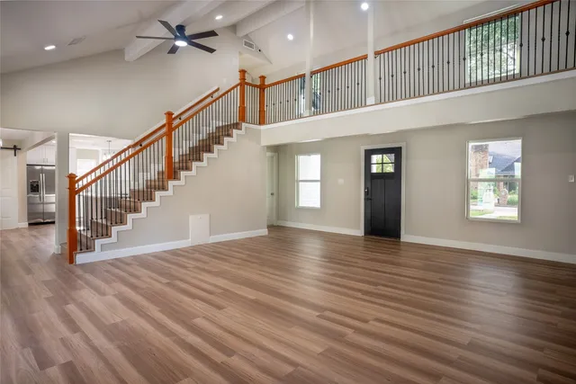 an empty room with windows and a ceiling fan