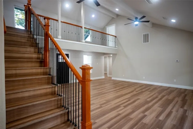 a view of a hallway with wooden floor and staircase