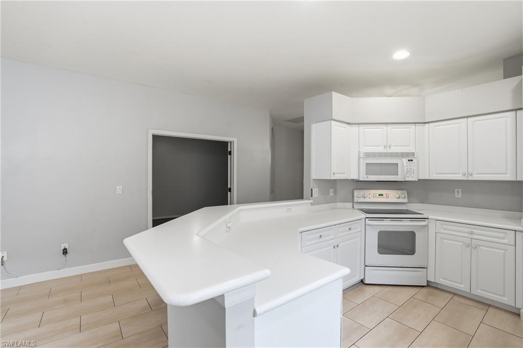 12517 Stone Valley Loop Fort Myers, FL 33913 - Photo 14 of 36 a kitchen with white cabinets stainless steel appliances and sink