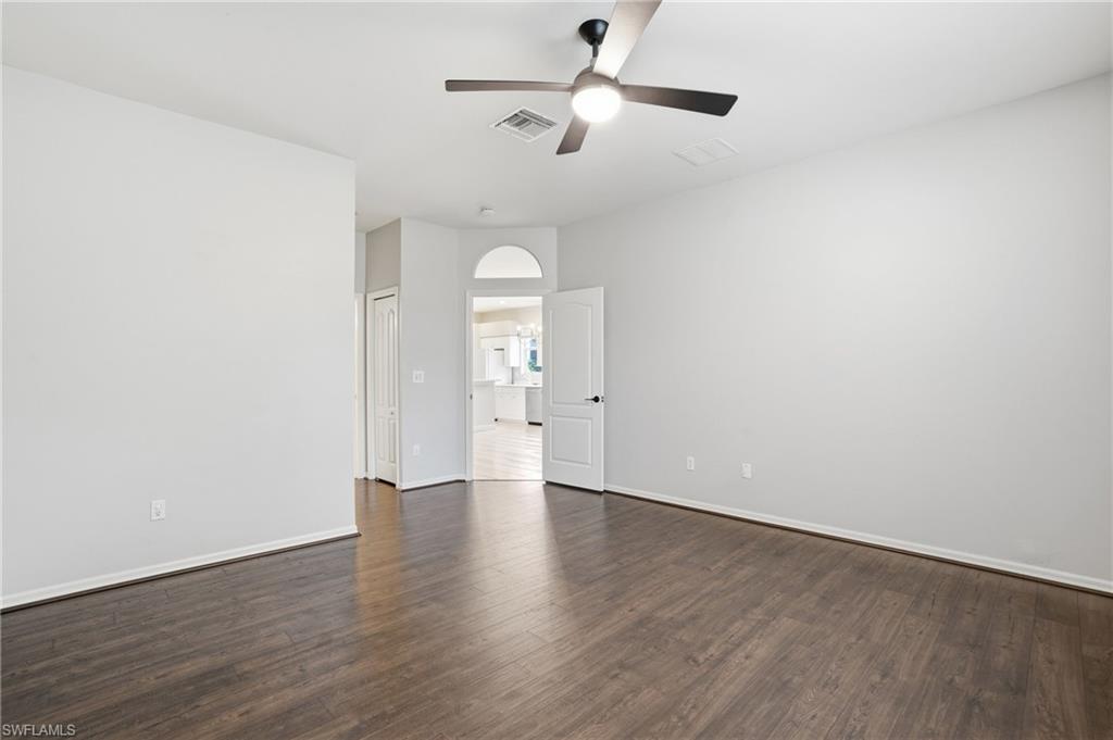 12517 Stone Valley Loop Fort Myers, FL 33913 - Photo 22 of 36 an empty room with wooden floor ceiling fan and windows