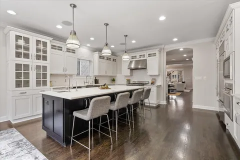 a kitchen with granite countertop white cabinets and stainless steel appliances