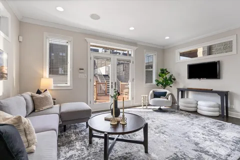 a living room with furniture a flat screen tv and a potted plant