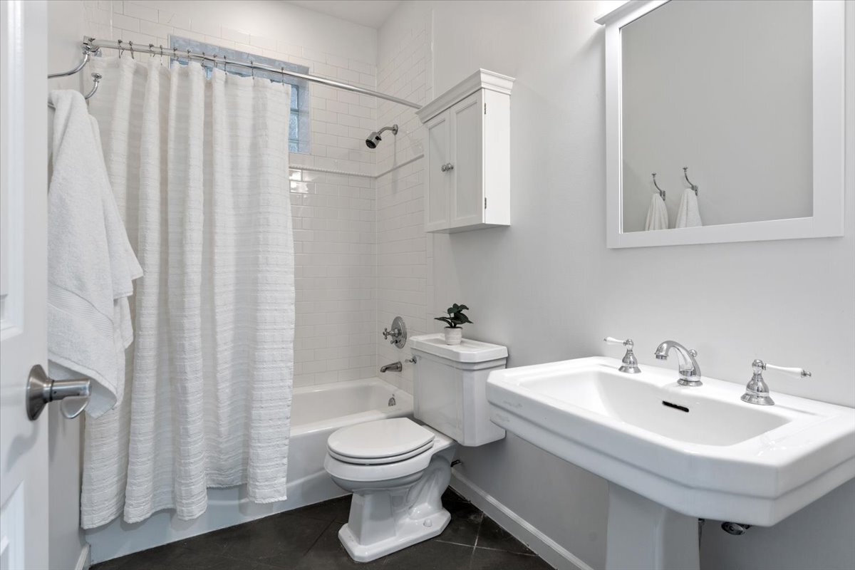 1937 West Melrose Street Chicago, IL 60657 - Photo 32 of 41 a bathroom with a white sink a toilet and shower curtain