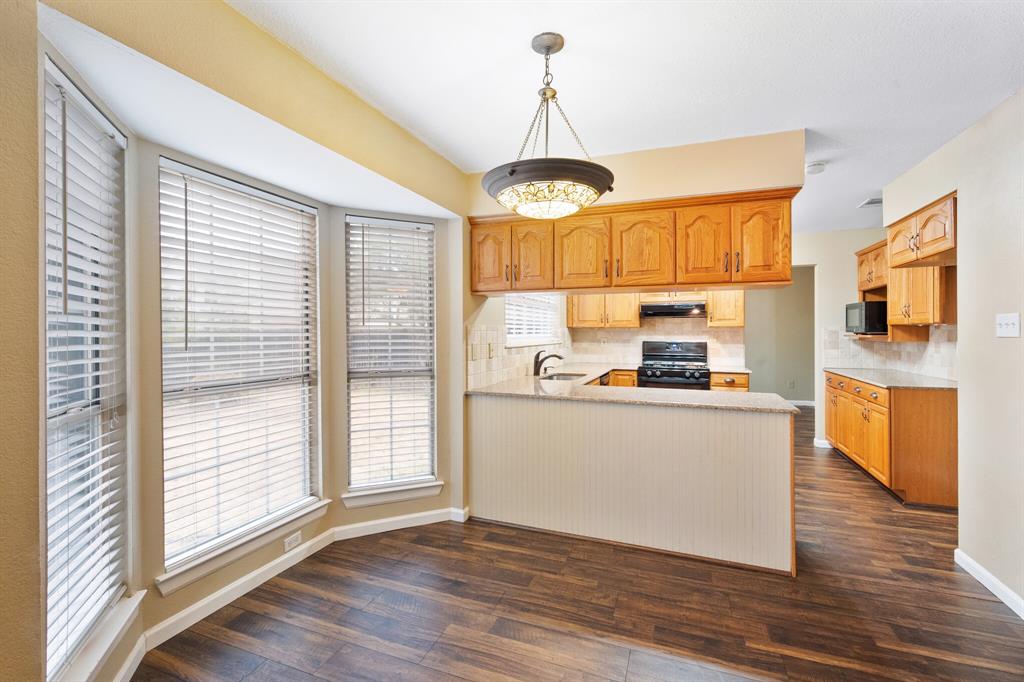 7517 Point Reyes Drive Fort Worth, TX 76137 - Photo 11 of 30 Dining area with a bay window, wood-finish flooring, and a decorative chandelier