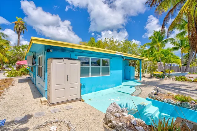 a front view of a house with a yard and covered with snow