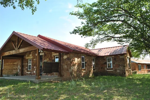 a view of a house with backyard and trees