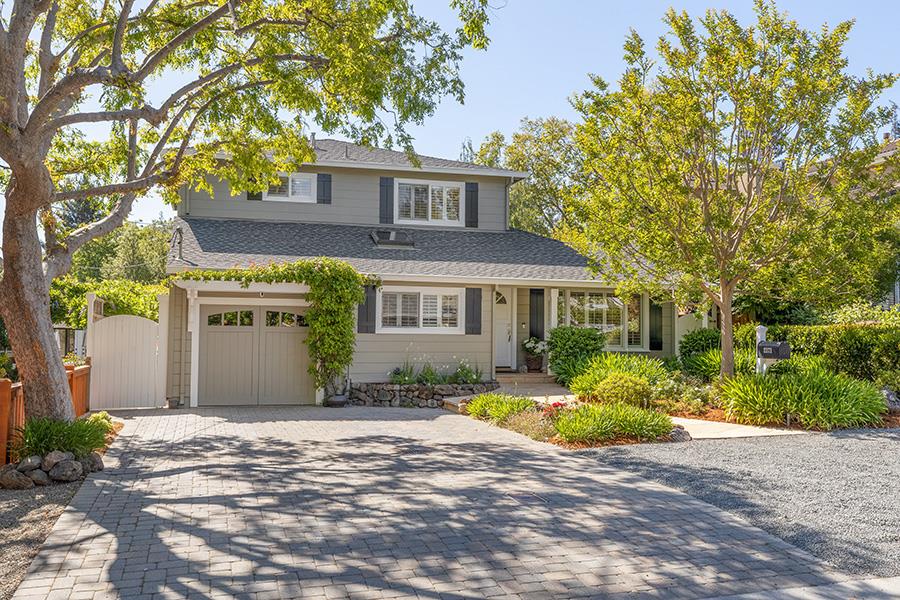 a front view of a house with a yard and potted plants