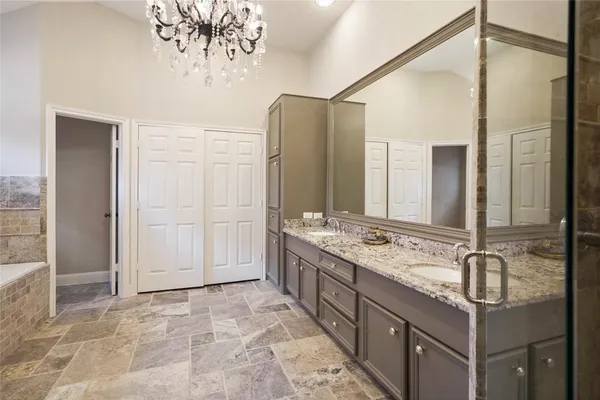 a bathroom with a granite countertop sink a mirror and a shower