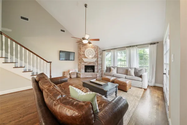 a living room with furniture a fireplace and a chandelier