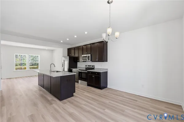 a kitchen with kitchen island white cabinets and stainless steel appliances