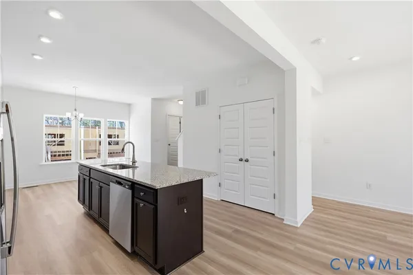 a kitchen with stainless steel appliances granite countertop a stove and a wooden floors