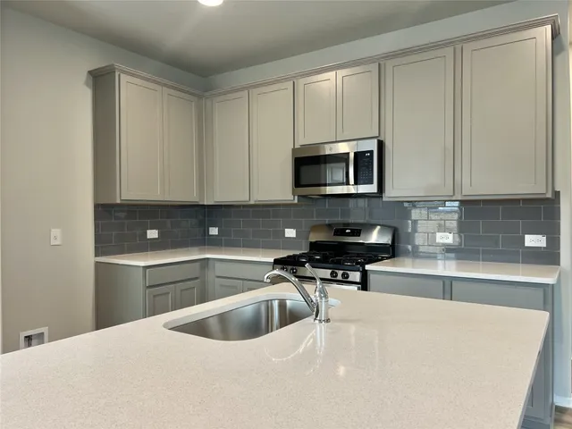a kitchen with a sink a stove and cabinets
