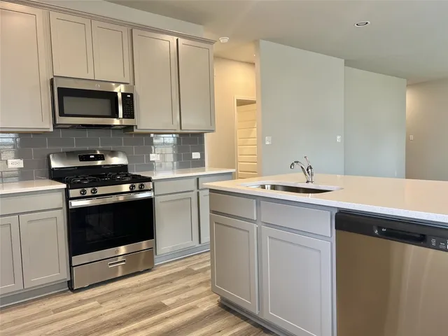 a kitchen with a sink stove and microwave