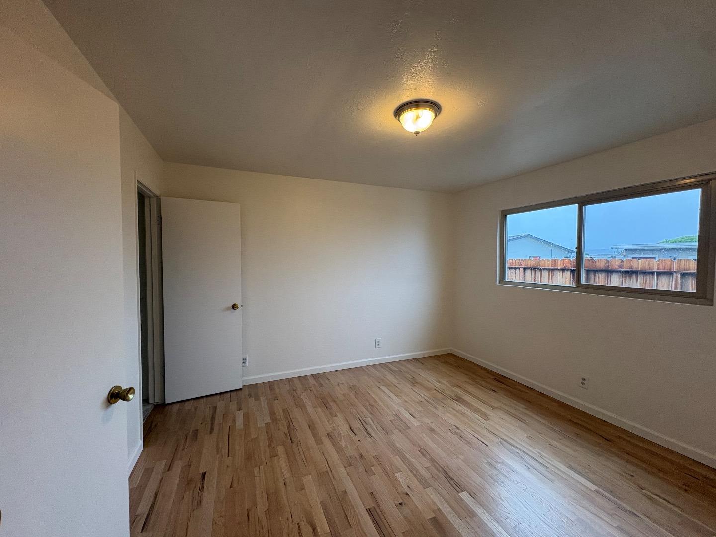 1675 Luxton Street Seaside, CA 93955 - Photo 18 of 33 a view of an empty room with wooden floor and a window