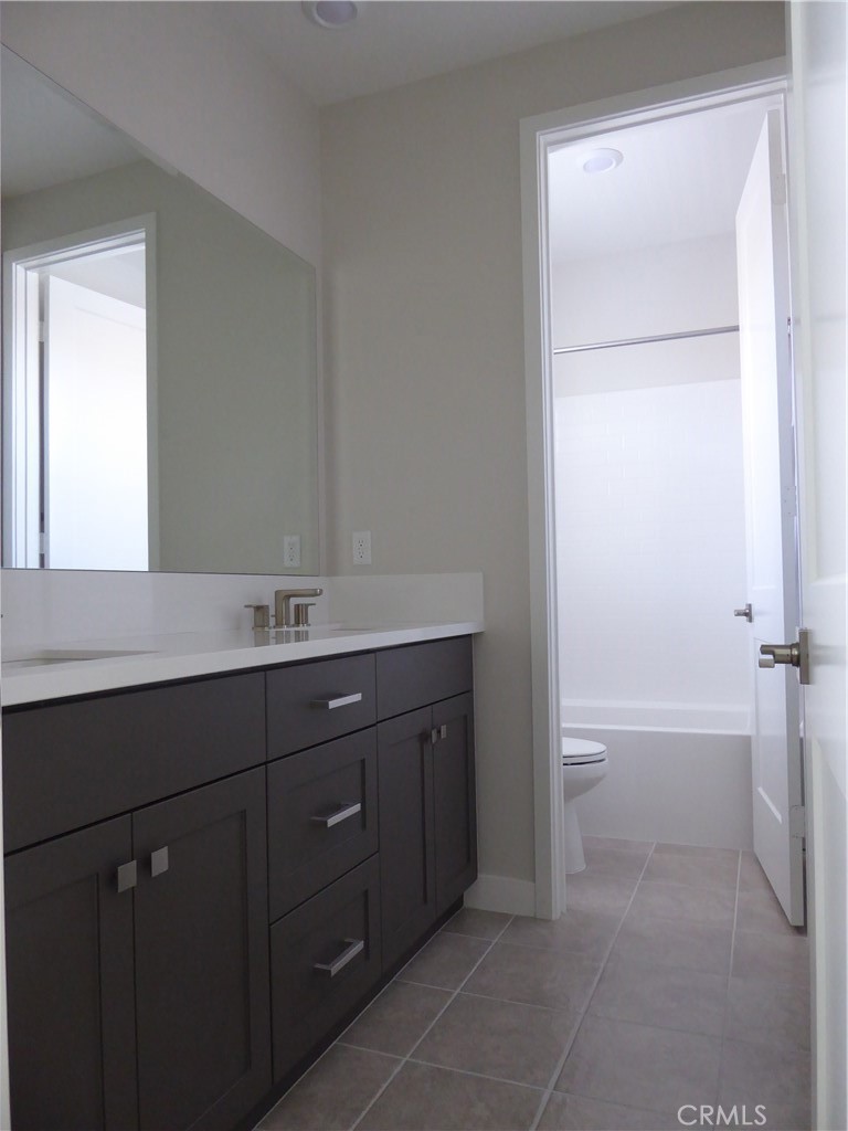 652 Athos Lake Forest, CA 92630 - Photo 13 of 13 a bathroom with a tub sink vanity and a toilet