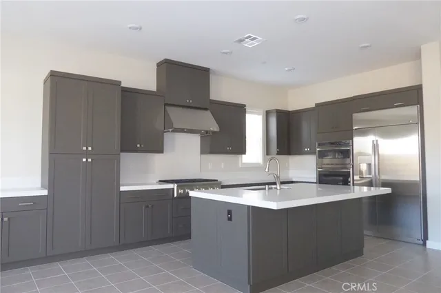a kitchen with stainless steel appliances a sink and a refrigerator