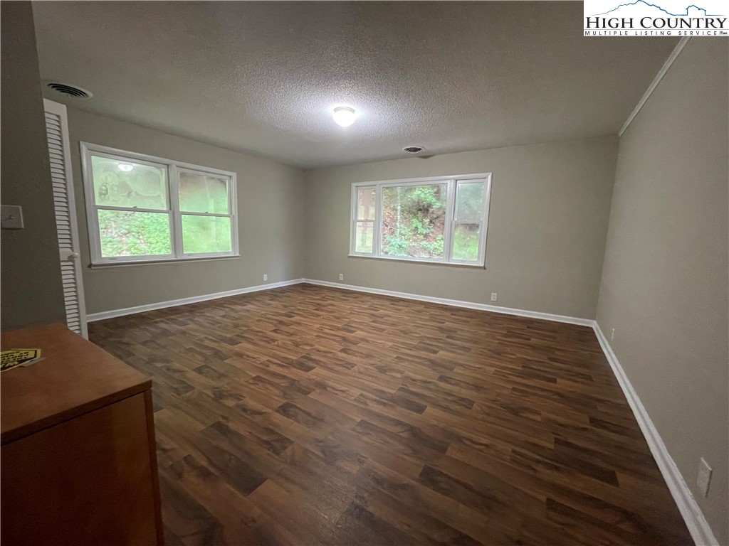 274 Bryan Davis Road Creston, NC 28615 - Photo 16 of 29 an empty room with wooden floor and windows