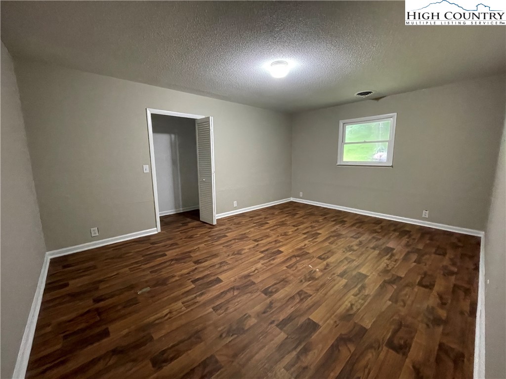 274 Bryan Davis Road Creston, NC 28615 - Photo 18 of 29 an empty room with wooden floor and windows